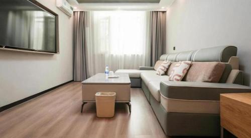 a living room with a couch and a table at GreenTree Inn Langfang Sanhe South Yingbin Road Express Hotel in Sanhe