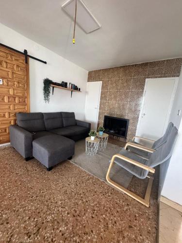 a living room with a couch and a chair at Casa en la montaña con jacuzzi exterior y piscina in Alcántara de Júcar