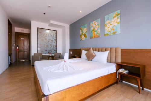 a bedroom with a large white bed in a room at Gardenia Hue Hotel in Hue