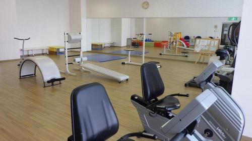 a gym with treadmills and exercise bikes in a room at Hotel Harvest Nankitanabe in Tanabe