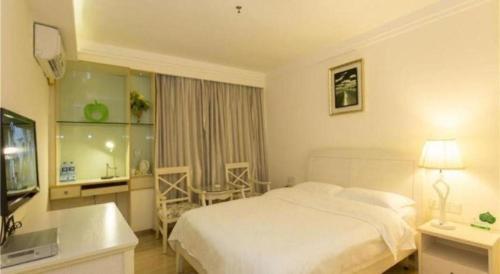 a hotel room with a white bed and a bathroom at 7 Days Inn Guangzhou Zoo Huanghuagang Metro Station in Guangzhou