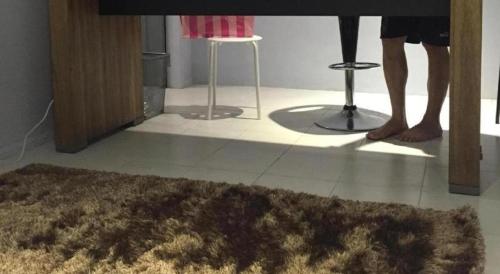 a couple of people standing in a living room with a rug at The Second Room in Ranau