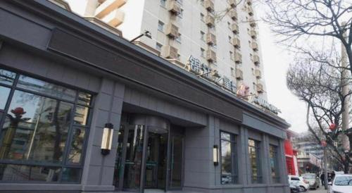 a building on a city street with a building at Jinjiang Inn Luoyang Wangcheng Park Metro Station in Luoyang