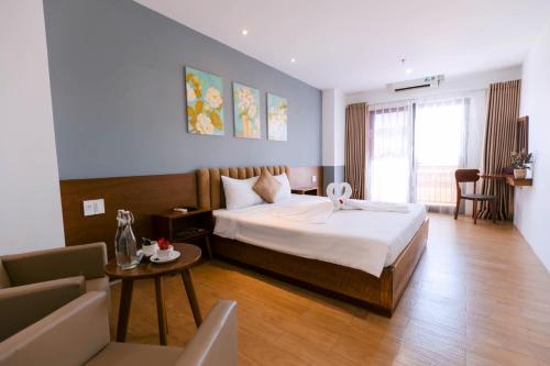 a hotel room with a bed and a table at Gardenia Hue Hotel in Hue