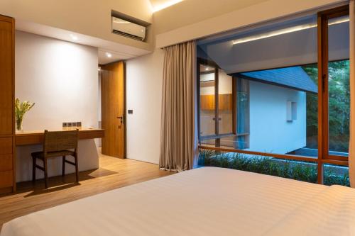 a bedroom with a desk and a large window at BRAND NEW Villa Manawa by Jawatra in Pererenan
