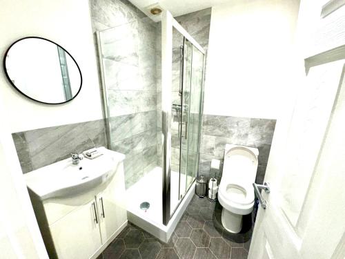 a bathroom with a sink and a toilet and a mirror at Best Location, Luxury, 2 to 8 guest, SkyTV and More in Liverpool