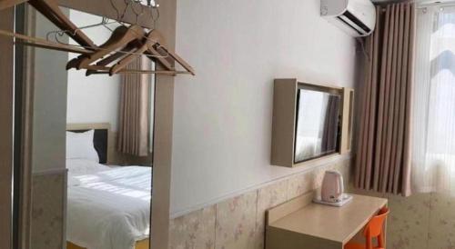 a hotel room with a bed and a mirror at 7 Days Inn·Taixing Wenchang Road in Taixing