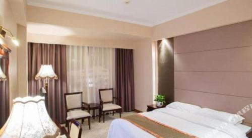 a hotel room with a bed and a table and chairs at Chaozhou Hotel in Chaozhou
