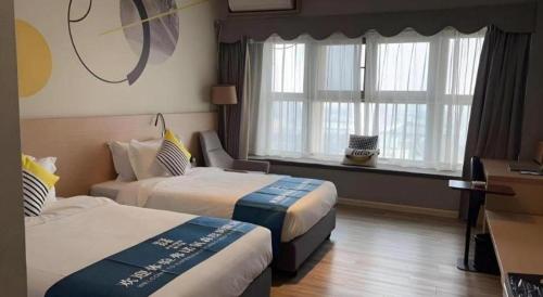a hotel room with two beds and a window at Imin Hotel in Huadu