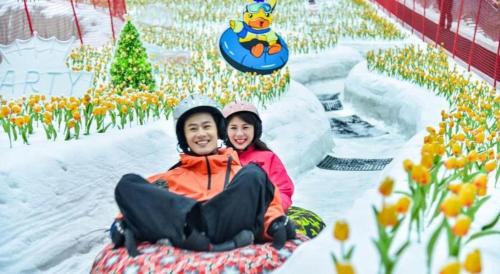 a man and a woman riding a roller coaster in the snow at Imin Hotel in Huadu
