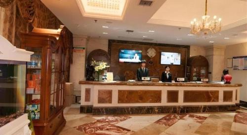 two people standing at a bar in a salon at GreenTree Alliance Anhui Hefei South Passenger Station South High Speed Railway Station Hotel in Hefei