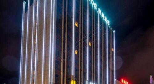 a tall building with lights on it at night at Lavande Hotels· Guizhou Anshun Xi Railway Station in Anshun
