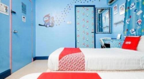 a bedroom with a bed and a blue wall at OYO 89958 Hotel Umimas in Lahad Datu