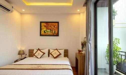 a bedroom with a bed and a window at Hoi An Paradise Villa in Hoi An