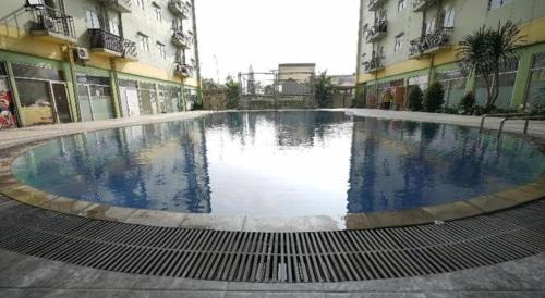 a large swimming pool in the middle of a building at OYO Living 3091 Apt The Suites Metro By Ananda in Bandung