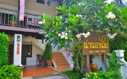 a sign in front of a building with plants at Nan Lanna Hotel in Nan