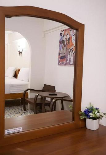 a reflection of a room with a table in a mirror at Nan Lanna Hotel in Nan