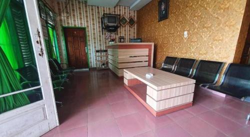 a room with a table and chairs and a door at Hotel O Losmen Bunda Arema in Bangko