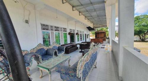 a living room with couches and chairs in a building at Hotel O Losmen Bunda Arema in Bangko