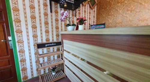 a counter in a store with flowers on the wall at Hotel O Losmen Bunda Arema in Bangko