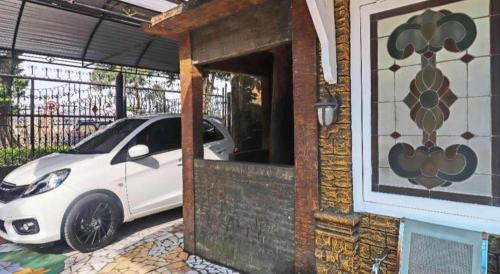 a white car parked outside of a building at OYO 2899 Ardilia Bandara Syariah in Jambi
