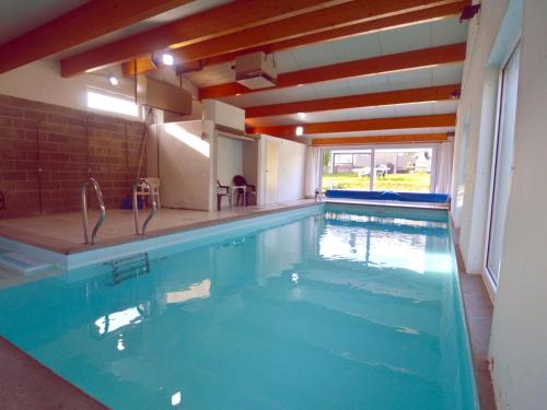 una gran piscina en una casa con en Quaint holiday home with heated indoor pool, en Purnode