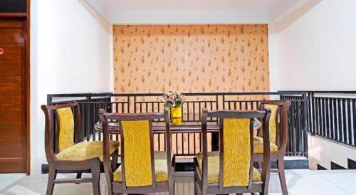 a table and chairs with a vase on a balcony at Hotel O Jawara Guest House Syariah in Bandung