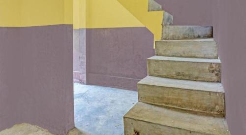 a stairway in a building with a yellow and purple wall at Hotel O Wonoayu Residence Syariah in Sidoarjo