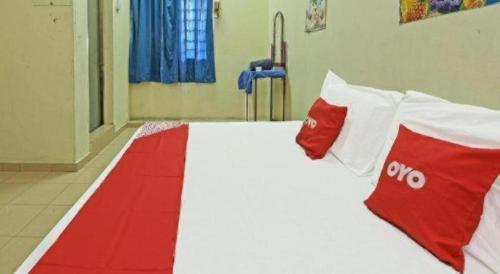 a bed with red and white pillows on it at SPOT ON 90625 Super Green Grass Hotel in Yong Peng