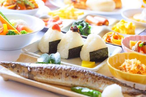 a plate of sushi with a fish and other foods at Ooedo Onsen Monogatari Minoh Kanko Hotel in Minoo