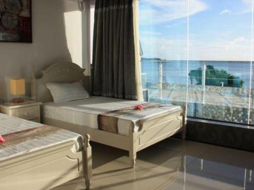 a bedroom with two beds and a large window at Crystal Palace Hotel in Port Vila