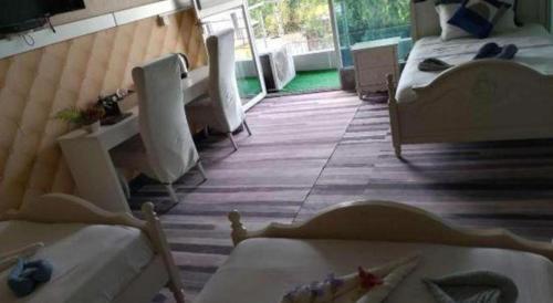 a room with two beds and a window and a room with at Crystal Palace Hotel in Port Vila