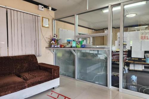 a living room with a brown couch and a counter at ONE Residence in Pathum Thani
