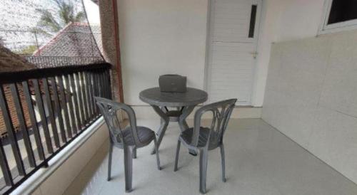 a small table and two chairs on a balcony at Hotel O Wisma Sidosari Syariah in Bandar Lampung