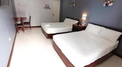 a hotel room with two beds and a chair at Sabine's Place in Masbate