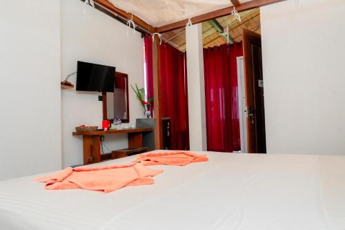 1 dormitorio con 1 cama con toallas de color naranja en Lucky Tuna, en Unawatuna