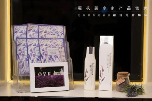 a shelf with two bottles and a picture and a box at Lavande Hotels Suzhou Railway Station in Suzhou