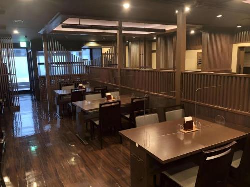 a restaurant with tables and chairs in a room at Hotel Route Inn Kitamatsudo Ekimae in Kashiwa