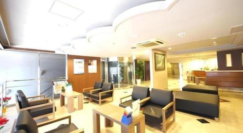a lobby with chairs and tables in a building at Hotel Route Inn Kitamatsudo Ekimae in Kashiwa