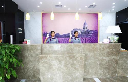 two women standing behind a counter in a room at Lavande Hotel Xi'an Longshouyuan Wenjing Road in Xi'an