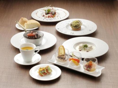a table with plates of food and a cup of coffee at Hotel Sunoak Kashiwanoha in Kashiwa