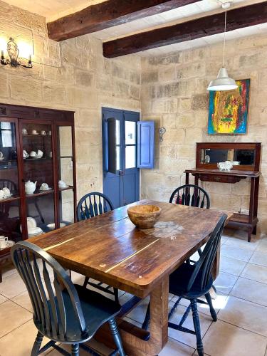 a dining room with a wooden table and chairs at Ta Skorba Farmhouse Mgarr in Mġarr