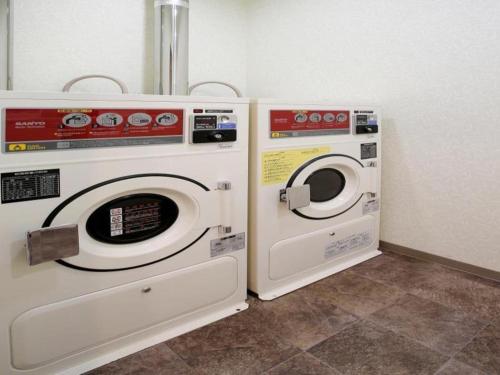 two washing machines sitting next to each other in a room at Hotel Sunoak Kashiwanoha in Kashiwa