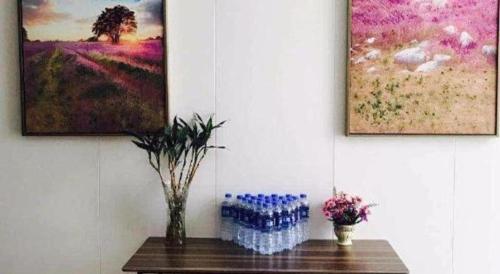 a table with two bottles of water and two paintings at Lavande Hotel Xi'an Longshouyuan Wenjing Road in Xi'an