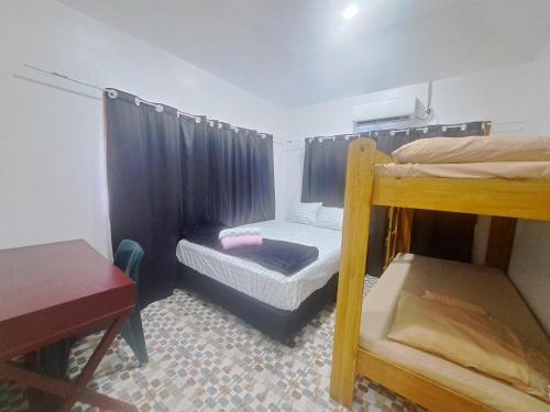 a small room with two bunk beds and a table at Laren Hi'ilani Homes in Apia
