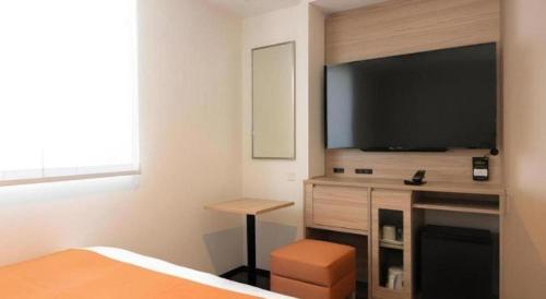 a bedroom with a flat screen tv on a wall at KEIKYU EX INN Hamamatsucho Daimon-Station (Tokyo) in Tokyo