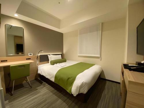 a bedroom with a bed with a desk and a mirror at KEIKYU EX INN Hamamatsucho Daimon-Station (Tokyo) in Tokyo