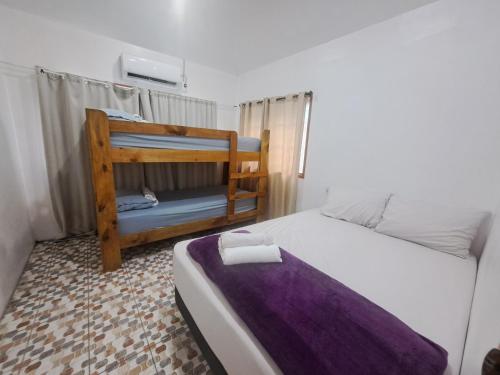 a bedroom with a bed with a purple blanket at Laren Hi'ilani Homes in Apia