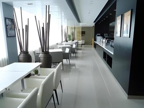 a dining room with white tables and white chairs at Jinjiang Inn Yancheng Funing Harbin Road in Yancheng