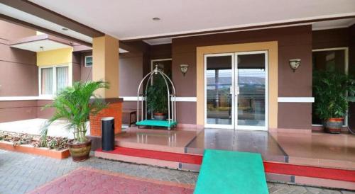 a lobby of a building with green chairs in it at Hotel Permata Bandara in Jakarta